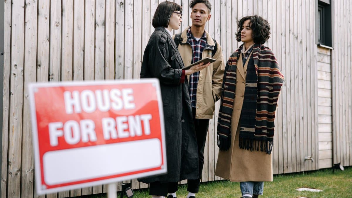 An interracial couple meets with a real estate agent to inquire about a house for rent.