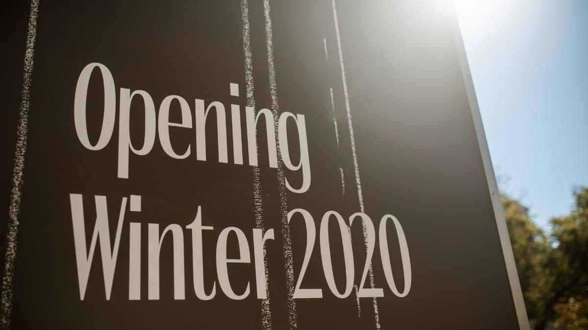Close-up of a sign reading 'Opening Winter 2020' with sun flare