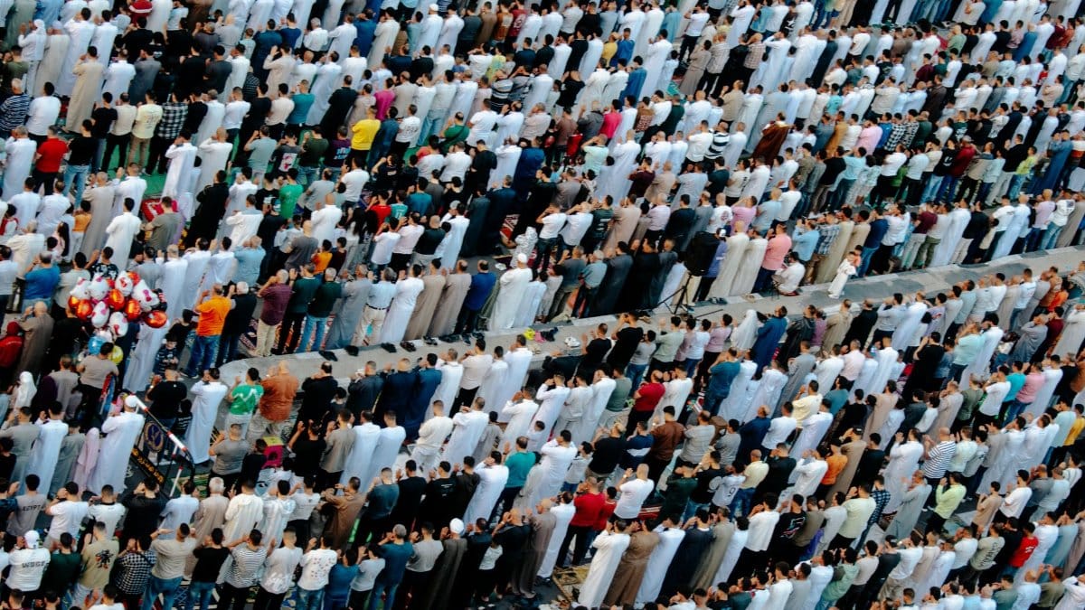 A diverse crowd of people gathered for a mass prayer in Egypt, seen from above.