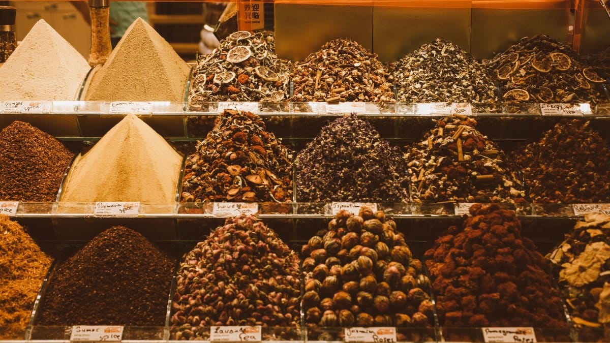 Colorful assortment of traditional spices on display in a vibrant market setting.