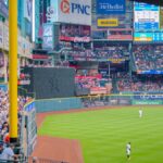 Vibrant baseball game scene with a full stadium, cheering crowd, and bright advertisements.
