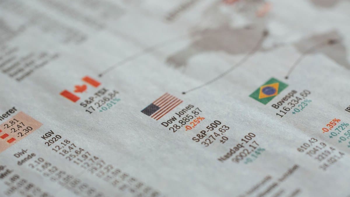 Detailed close-up of a newspaper displaying global financial market statistics and country flags.