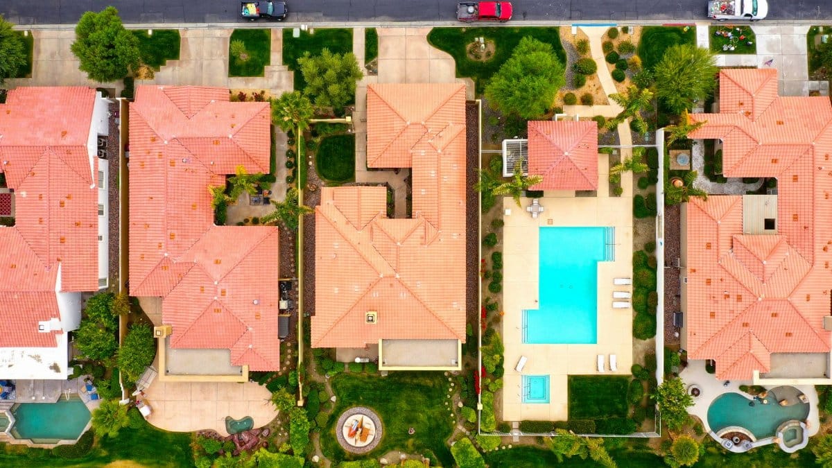 Aerial view showing suburban homes with pools in La Quinta, California, highlighting luxury lifestyle.