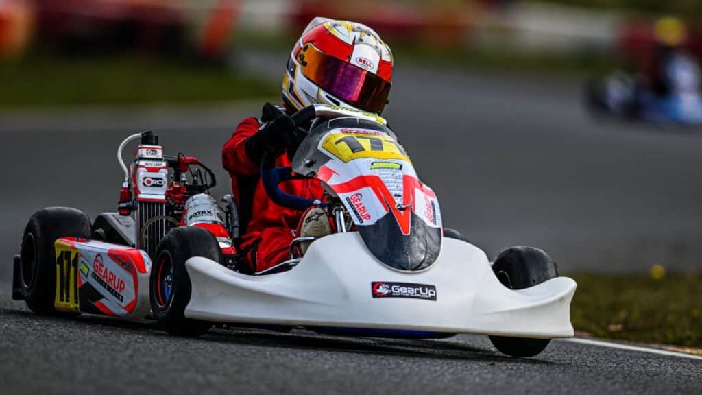 A thrilling go-kart race with driver navigating the circuit track at high speed.