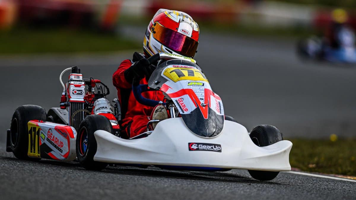 A thrilling go-kart race with driver navigating the circuit track at high speed.