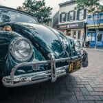 A classic green vintage car parked on a quaint brick street in Annapolis, Maryland.