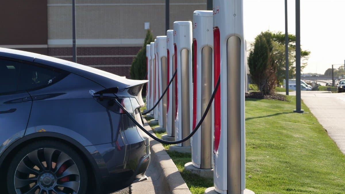 Electric car plugged into a row of charging stations, showcasing modern EV infrastructure.
