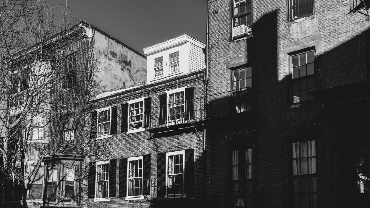 Black and white photo of historic brick buildings in Beacon Hill, Boston, capturing architectural details.
