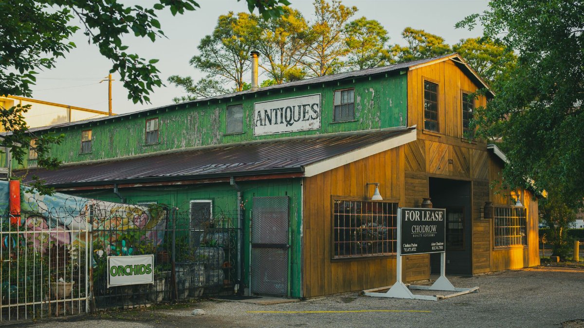 Rustic green and yellow antique shop exterior in Houston, Texas, with 'For Lease' sign.