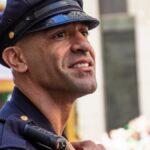 A San Francisco police officer in uniform smiling during an outdoor event.