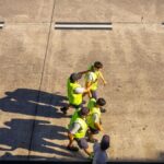 Aerial view of airport workers walking on the tarmac in Buenos Aires on a sunny day.