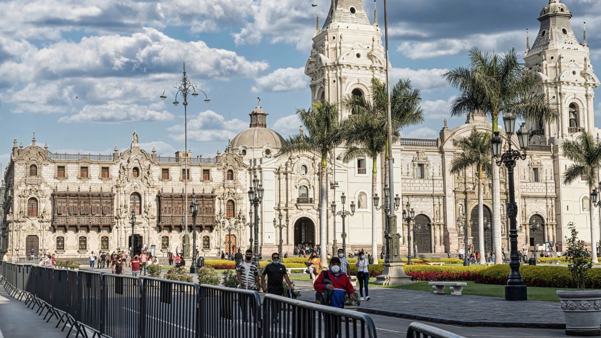 A bustling Plaza Mayor in Lima showcasing the historic Cathedral of Lima under blue skies.