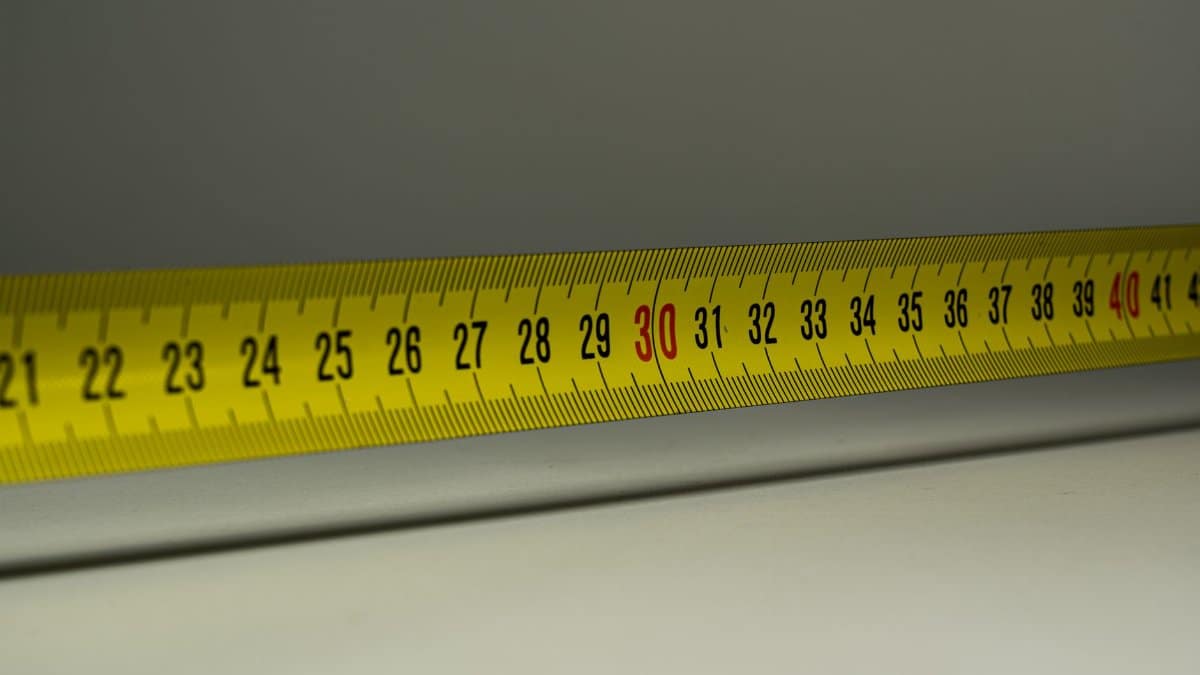 Close-up view of a yellow measuring tape with centimeter marks, emphasizing precision in measurement.