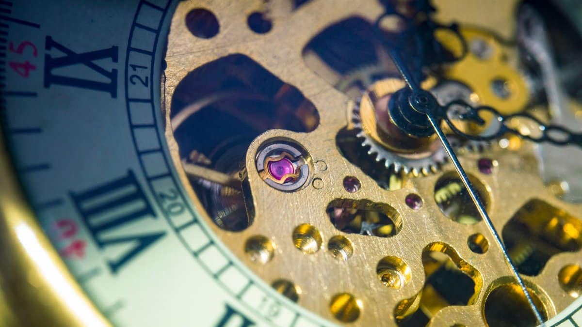 Detailed close-up of a vintage pocket watch showcasing its intricate gold mechanical gears.