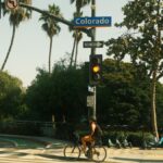 Bicyclist waits at traffic light on Colorado Street in sunny Los Angeles.