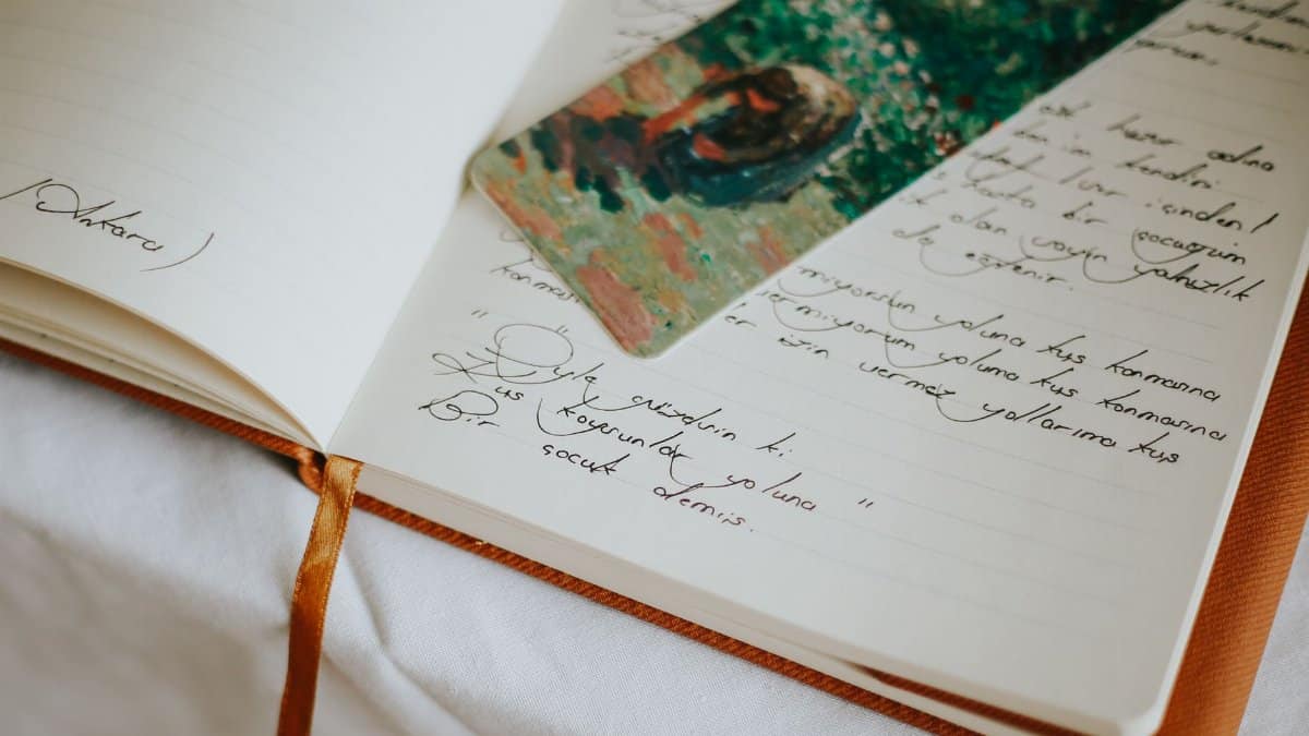 A close-up of an open journal with handwritten text and a colorful bookmark, evoking creativity.
