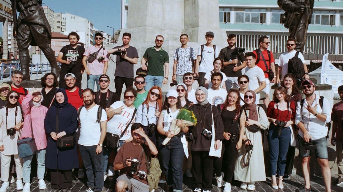 A large group of tourists gathered at a city square in front of statues, perfect for travel-themed projects.