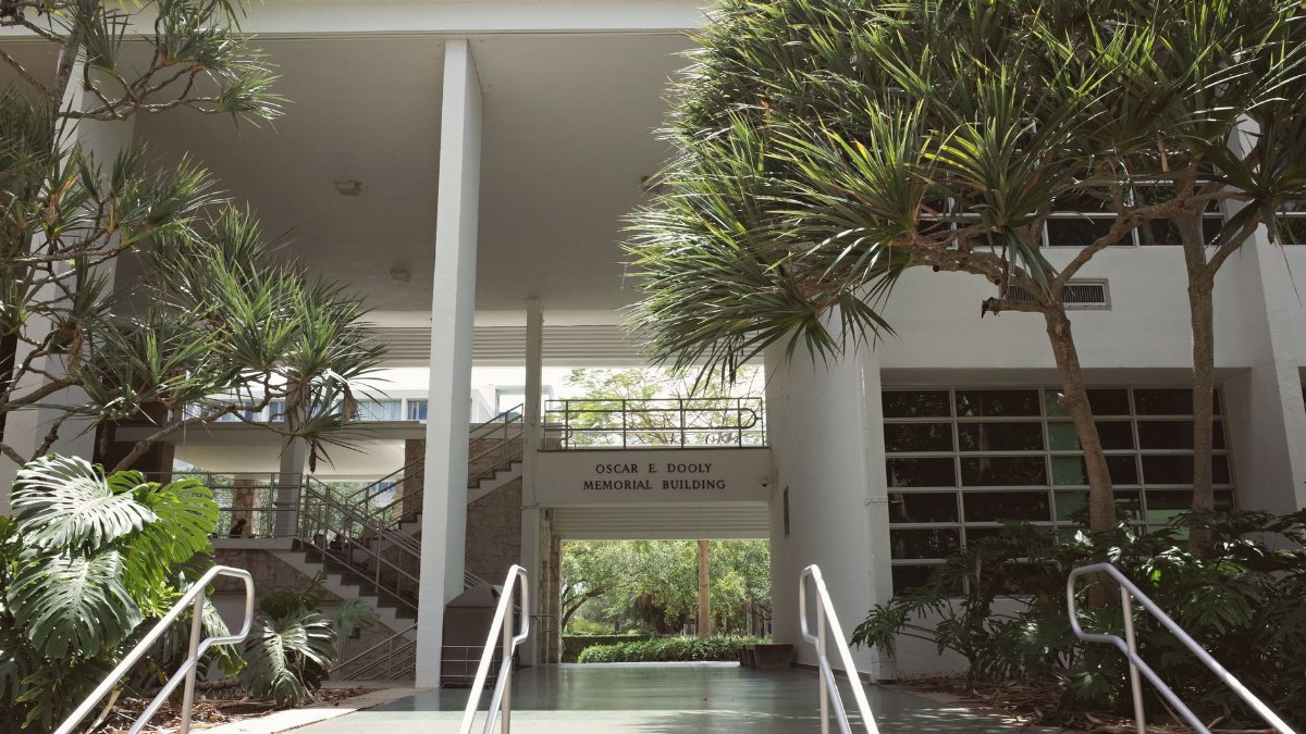 An outdoor view of the Oscar E. Dooly Memorial Building at a university campus with surrounding greenery.