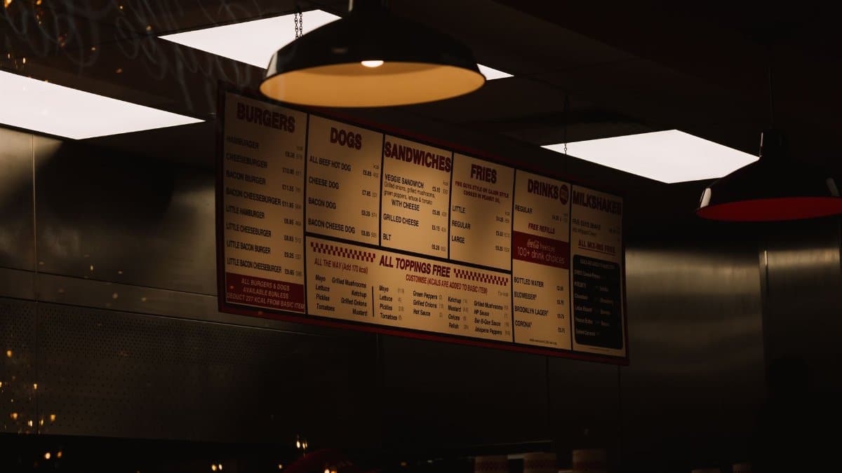 Dimly lit fast food restaurant interior with visible menu and ceiling lighting.