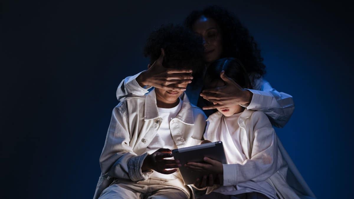 A mother oversees her children using a tablet, emphasizing safety and supervision in digital media use.