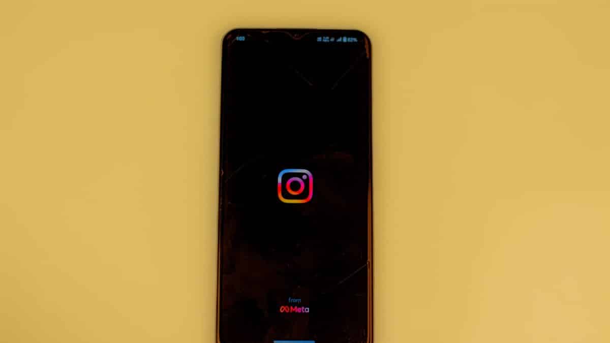 A smartphone displays the Instagram logo on a vibrant yellow background, emphasizing modern social media themes.