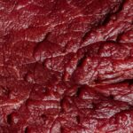Detailed close-up of raw beef meat showcasing its rich texture and marbling.
