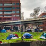 Homeless encampment with tents in downtown Portland under an overpass, capturing social issues.