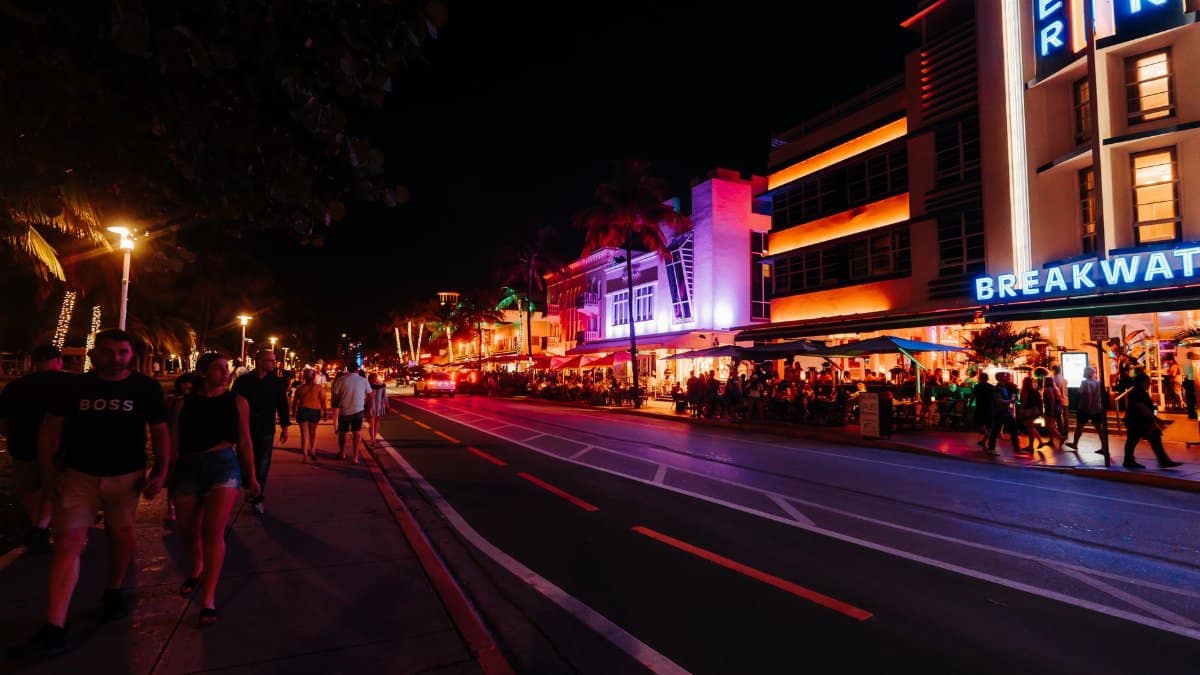 Explore the vibrant nightlife with neon lights and crowded streets on Miami's famous Ocean Drive.