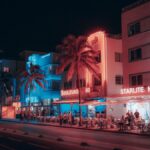 Colorful Art Deco hotels and lively street scene on Ocean Drive at night in Miami Beach.