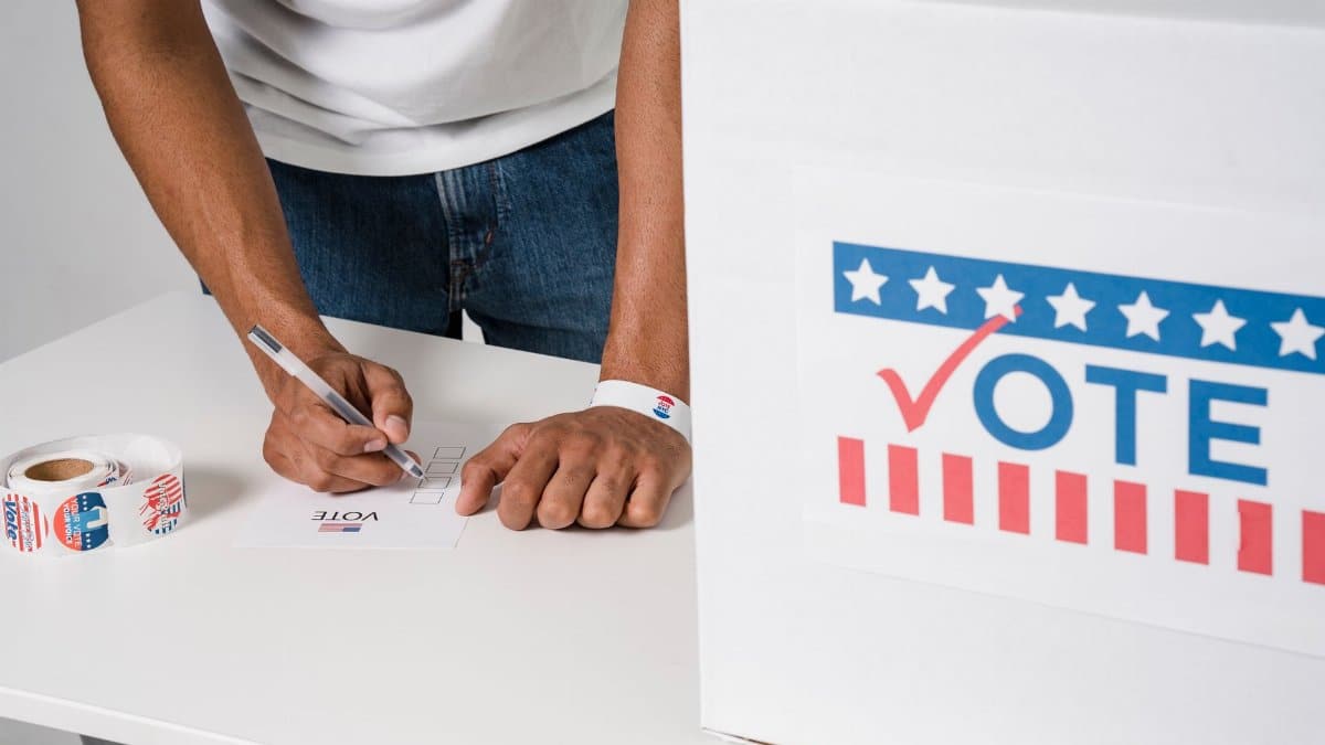Close-up of man voting at ballot box, emphasizing democratic participation.