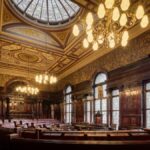 Elegant interior of Glasgow City Chambers featuring intricate details and stained glass windows.