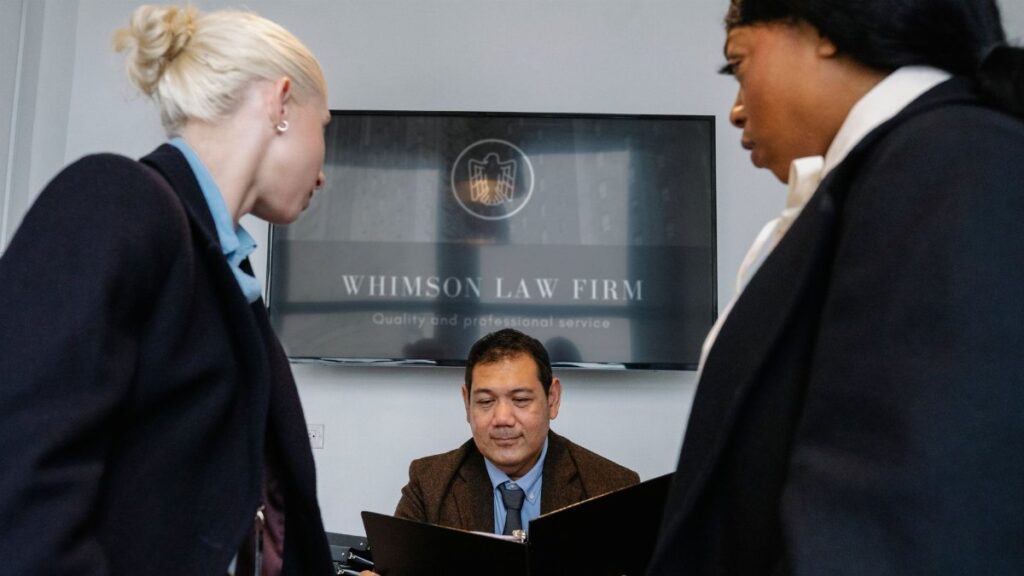 Diverse colleagues gathering in conference hall of law firm and discussing details of contract while working together