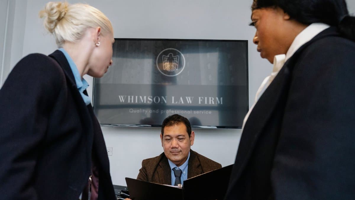 Diverse colleagues gathering in conference hall of law firm and discussing details of contract while working together