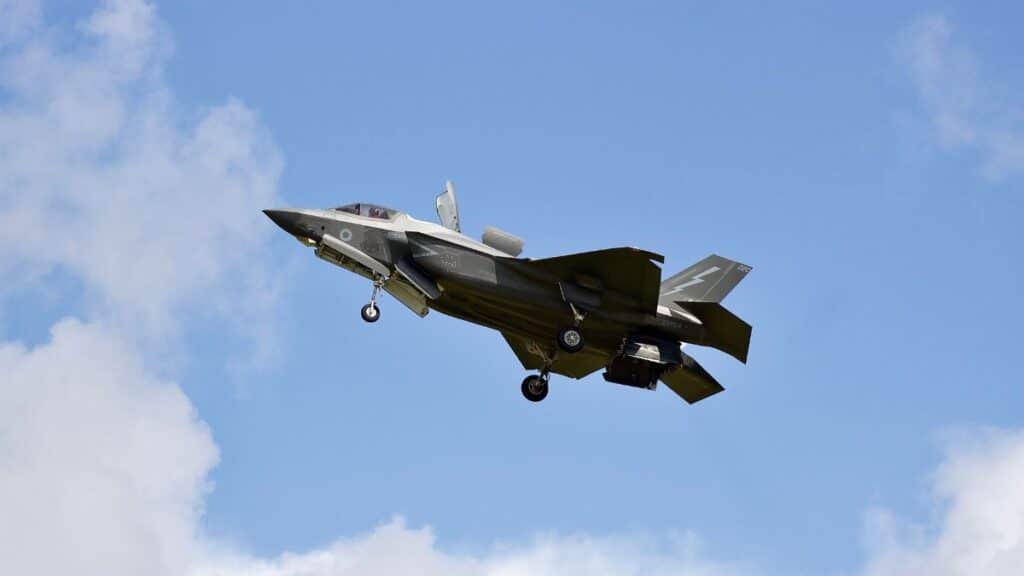 F-35 Lightning II military jet flying in clear skies over England.