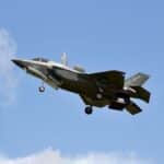 F-35 Lightning II military jet flying in clear skies over England.