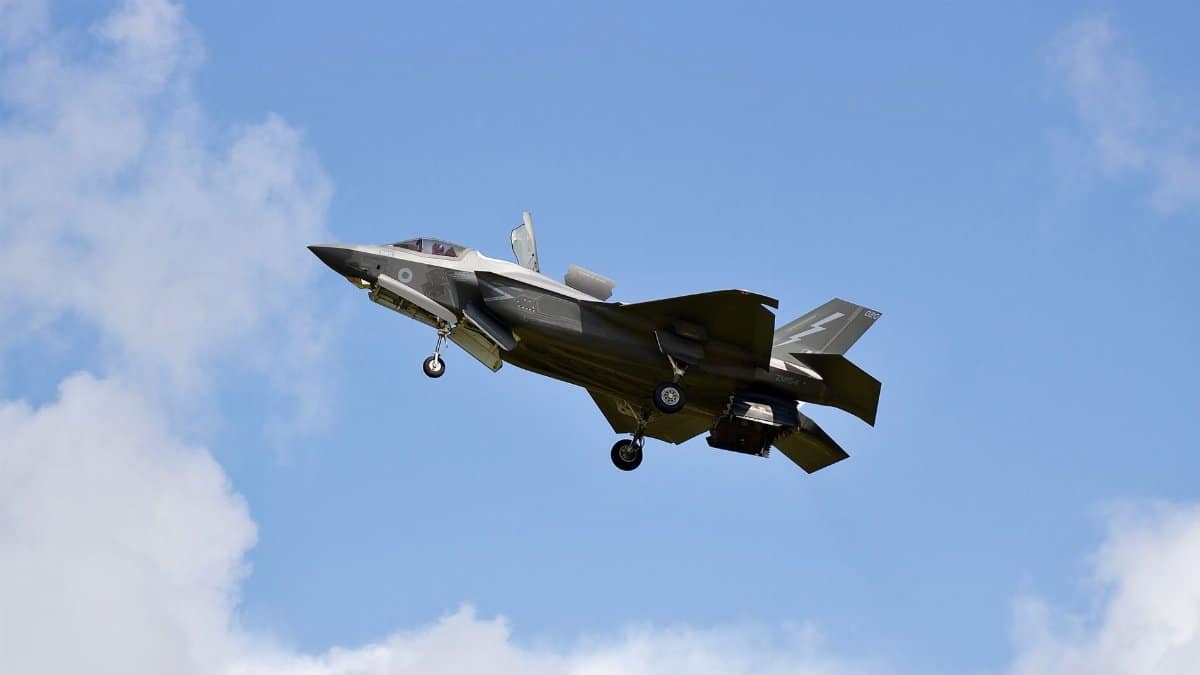 F-35 Lightning II military jet flying in clear skies over England.