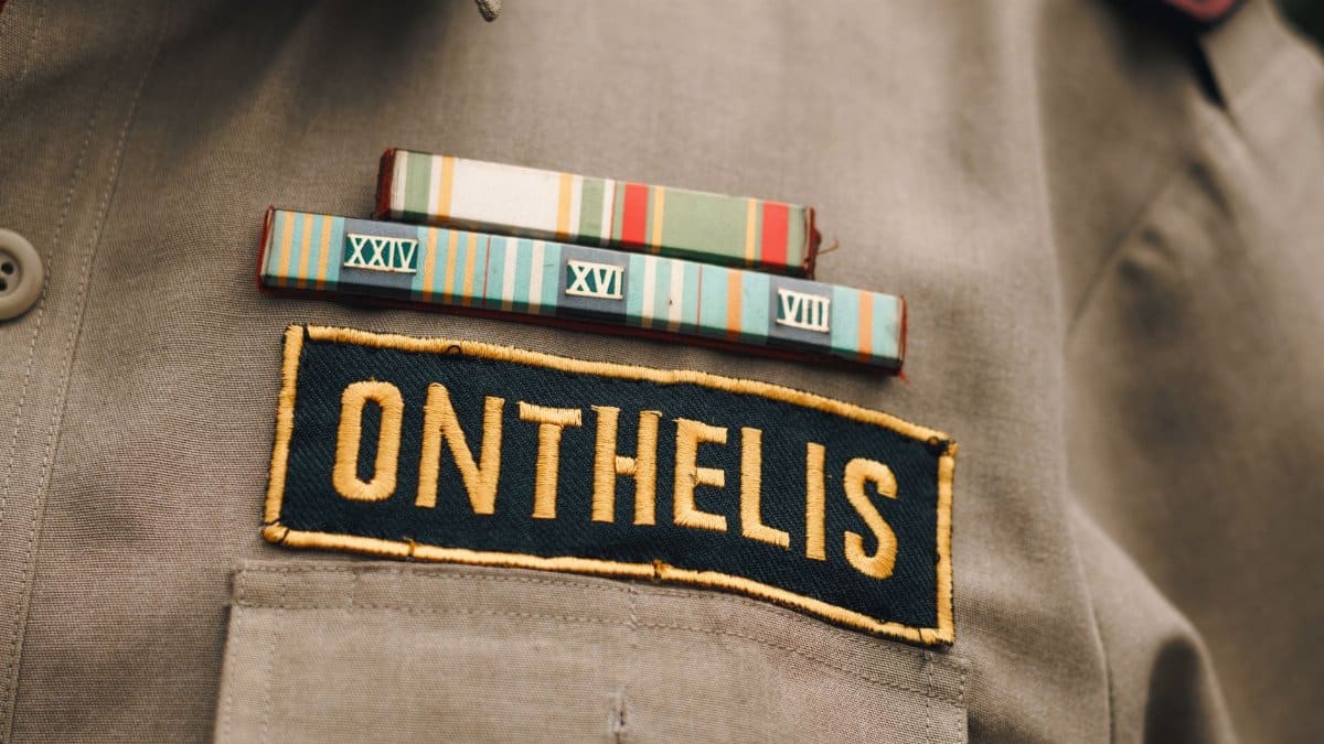 Detailed view of a military uniform highlighting a name tag and colorful service ribbons, symbolizing honor and service.