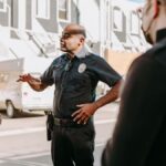 A police officer interacting with civilians during a peaceful protest in an urban setting.