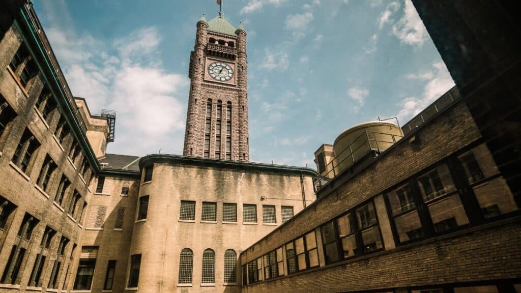 Aerial view of a historic clock tower in a sunny Minneapolis courtyard.