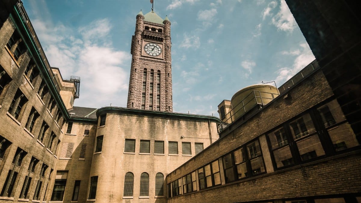 Aerial view of a historic clock tower in a sunny Minneapolis courtyard.