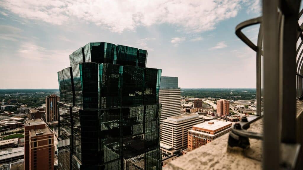 Aerial view of a modern skyscraper and cityscape in Minneapolis, Minnesota under a bright sky.