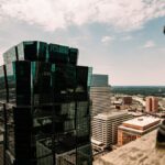 Aerial view of a modern skyscraper and cityscape in Minneapolis, Minnesota under a bright sky.