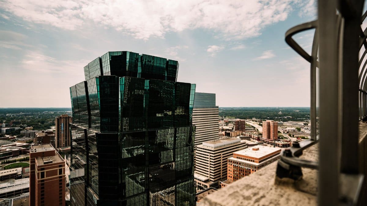 Aerial view of a modern skyscraper and cityscape in Minneapolis, Minnesota under a bright sky.