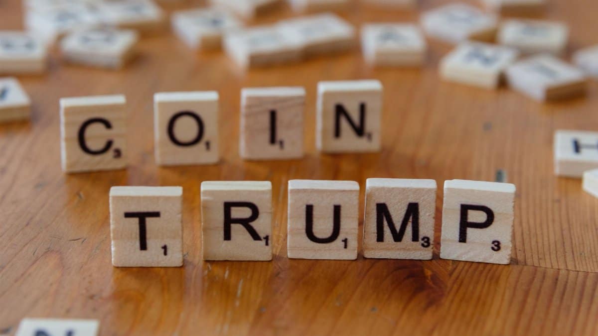 Scrabble tiles spelling 'TRUMP' on a wooden table, creating a political theme.