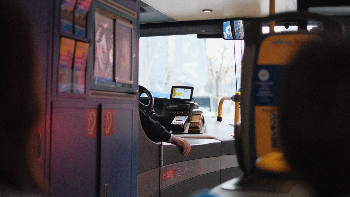 A modern bus interior showcasing the driver's area during daylight hours.