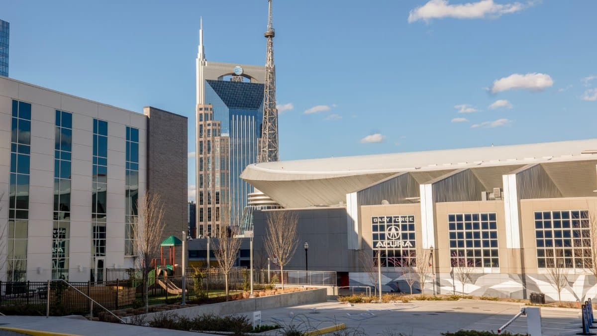 Skyline view featuring Nashville's iconic AT&T Building, modern architecture under blue skies.