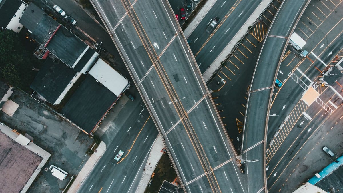 A top-down view of a busy urban expressway intersection with multiple lanes and flyovers.