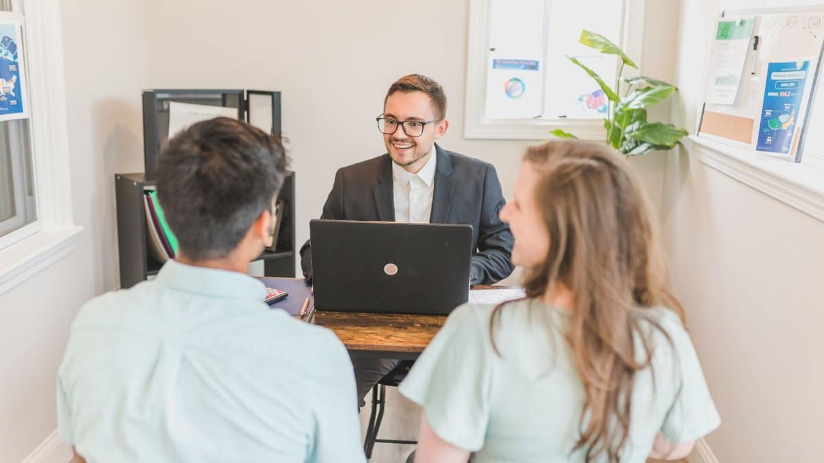 Couple consulting with a real estate agent about buying a new home in a bright and modern office.