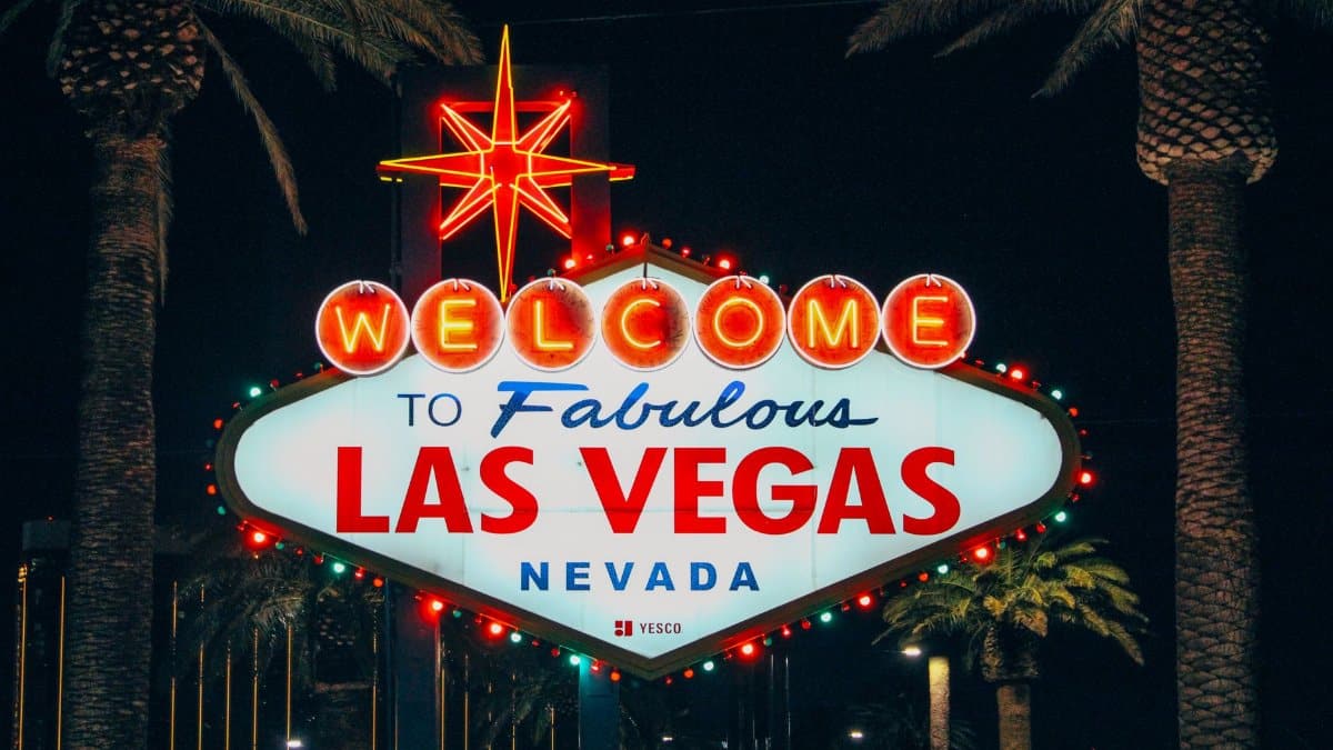 The iconic Welcome to Fabulous Las Vegas sign illuminated at night with palm trees in the background.