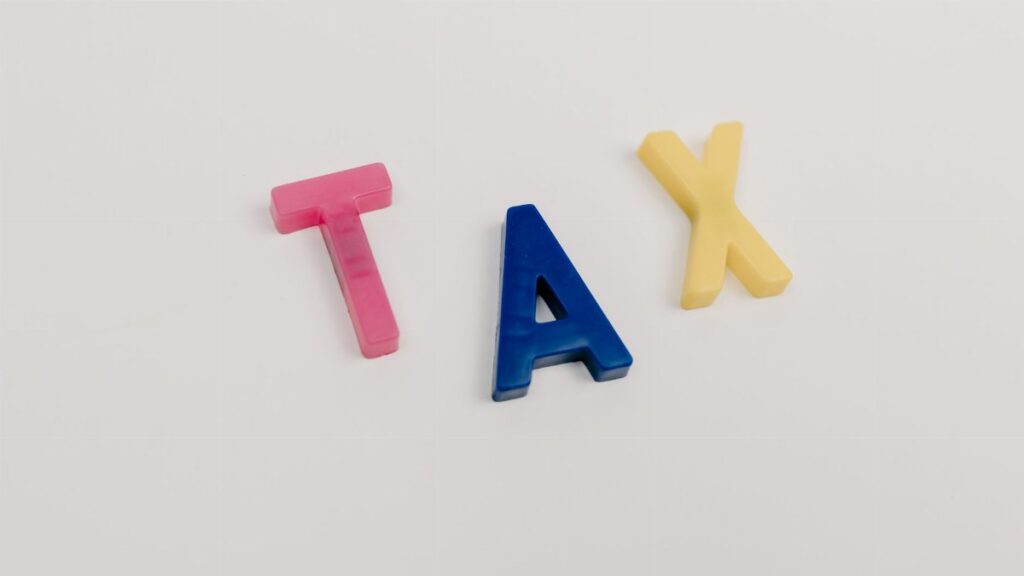 Colorful plastic letters spelling tax on a clean white background.